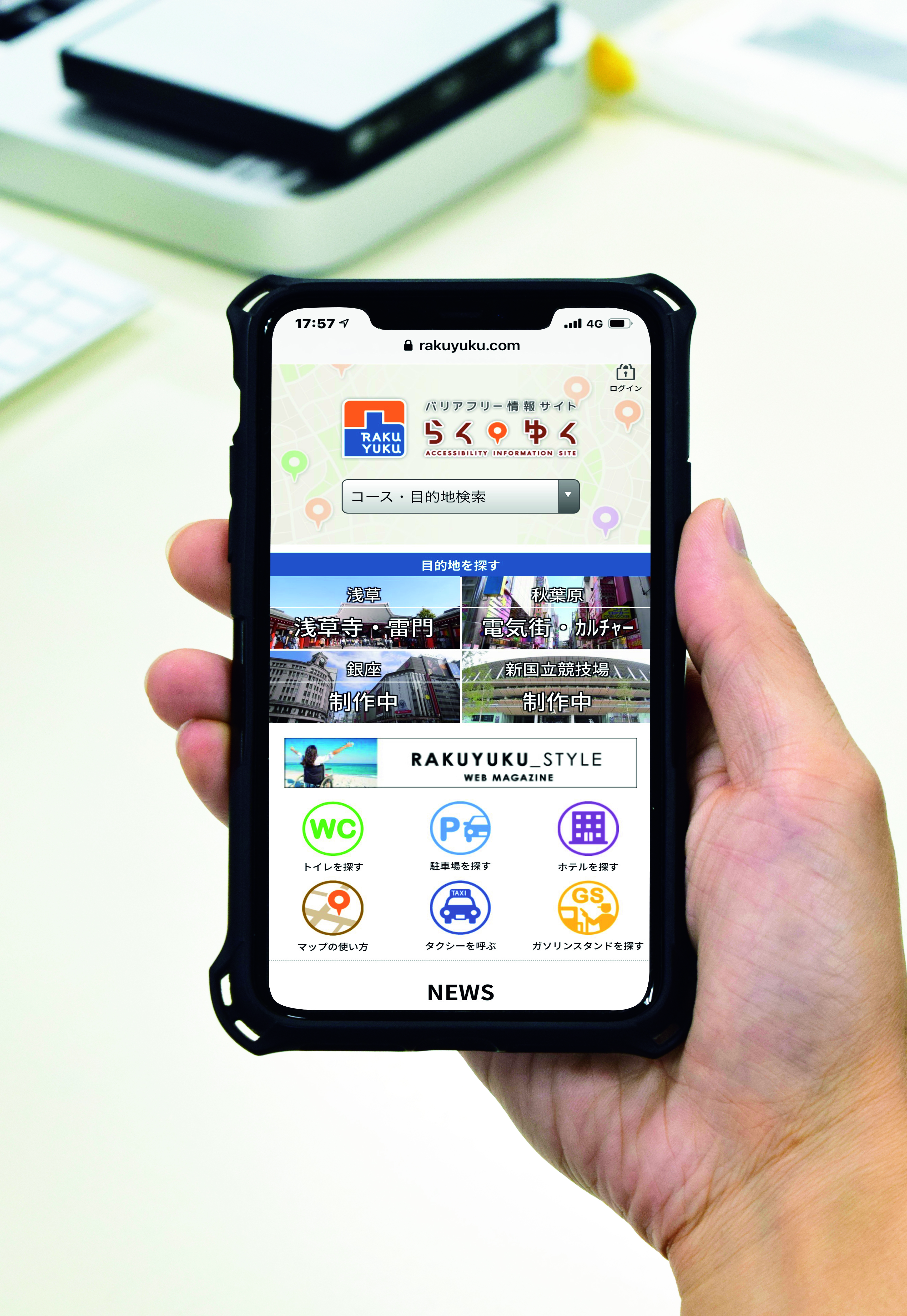 手に持ったスマートフォンにらくゆくのウェブサイトが表示されている写真
