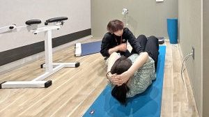 "パーソナルサポートの様子。専門スタッフのアドバイスを受けながら上体起こし運動を行っている社員。